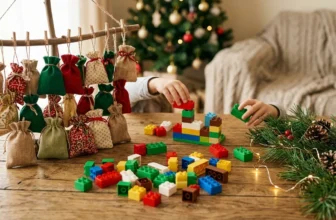 Bunte Bausteine und Türchen-Schachteln auf Holztisch mit Tannenzweigen